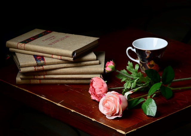 Ein Bücherstabel und Rosen auf einem Tisch